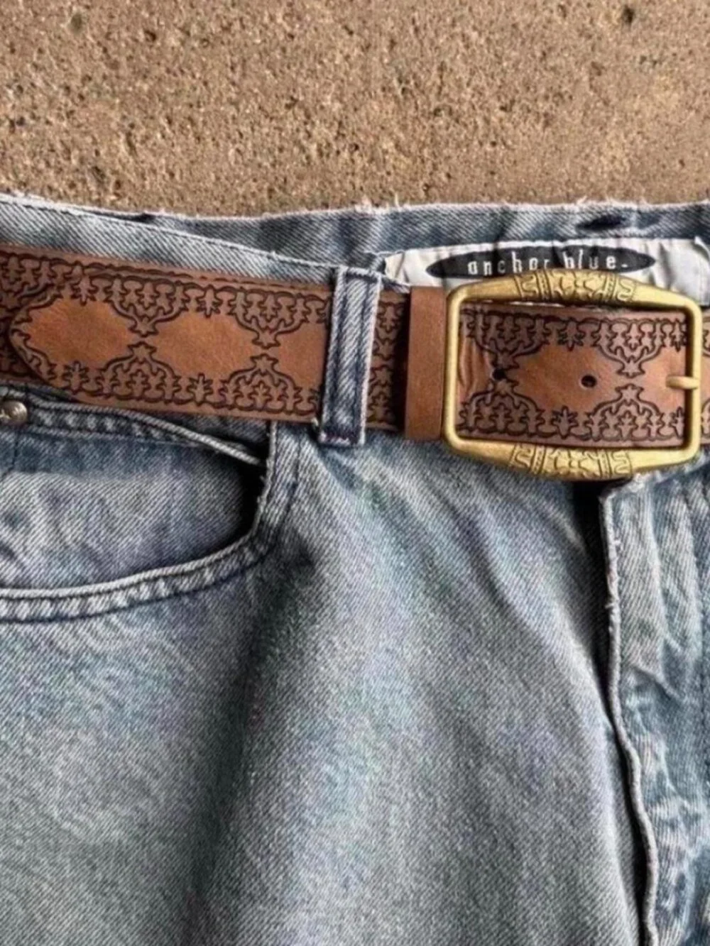 brown belt with embossed floral and scrollwork design